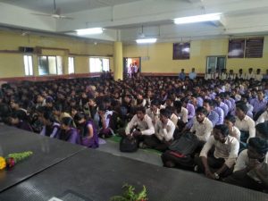 a brown French bulldog puppy laying down and looking up with a hopeful look in its eyes.
