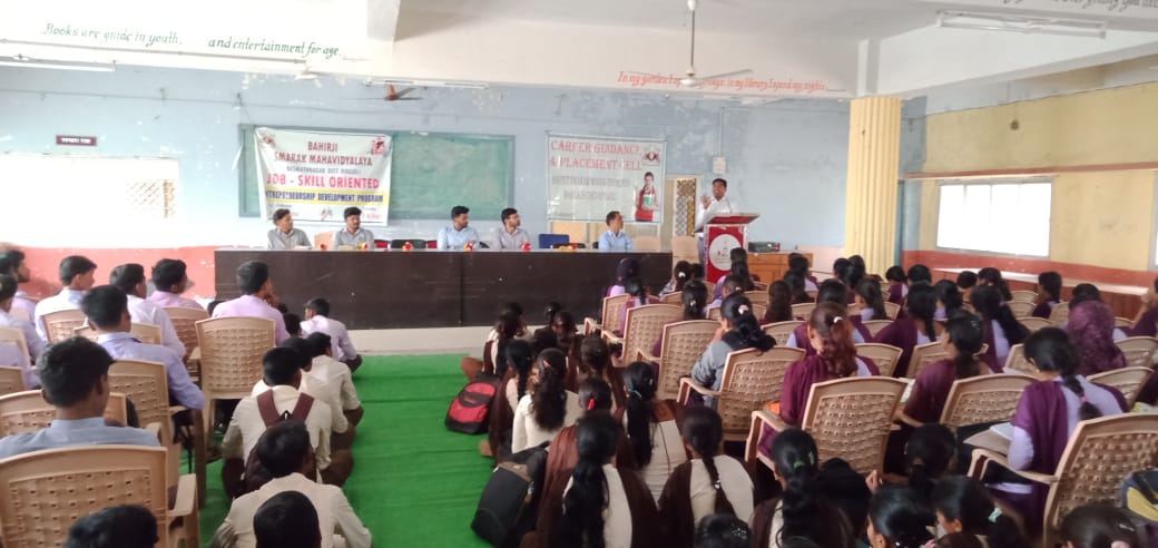 A light brown, long-haired chihuahua sitting next to three rubber duckies.