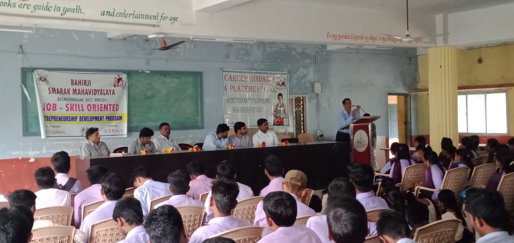 A light brown puppy standing on a white and tan woven pet bed.