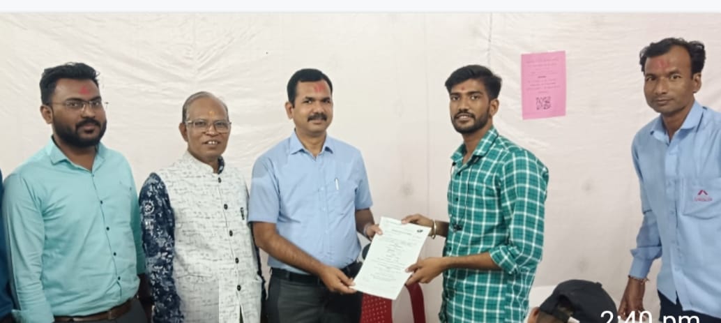 A light brown puppy standing on a white and tan woven pet bed.
