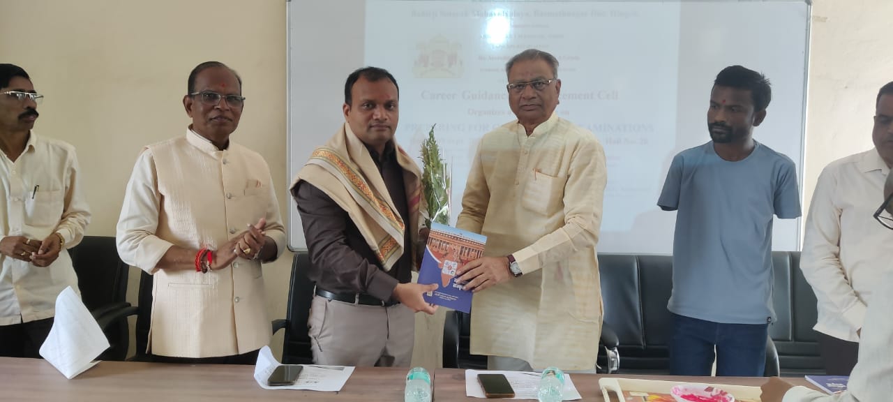 A light brown puppy standing on a white and tan woven pet bed.