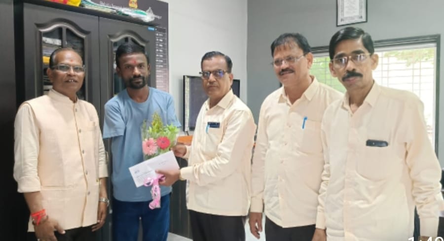 A light brown puppy standing on a white and tan woven pet bed.
